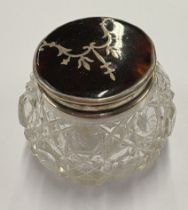 A silver and faux tortoiseshell-lidded glass jar.