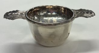 A silver-plated tea strainer on stand.