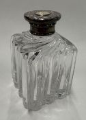 A silver-gilt-lidded glass perfume bottle.