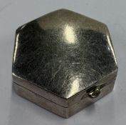 An octagonal silver pill box.