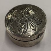 An engraved silver pill box.