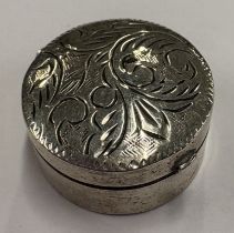 An engraved silver pill box.