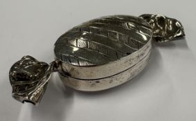 A silver pill box in the form of a sweet.
