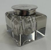 A silver-lidded glass inkwell.
