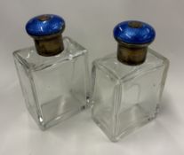 A pair of silver-lidded and blue enamelled glass scent bottles.