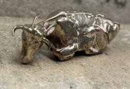 An unusual silver finial in the form of a seated bull. London. Approx. 14 grams. Est. £50 - £80.