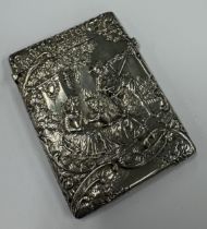 A novelty embossed silver card case decorated with musical scenes to one side and garden scene