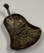 A 19th Century silver caddy spoon with chased grape and vine decoration, apparently unmarked.