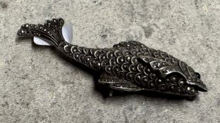 A silver brooch in the form of a fish.