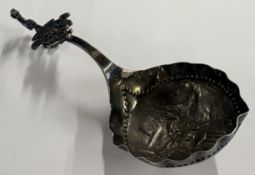 A Continental silver caddy spoon with chased decor