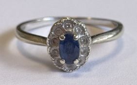 A small sapphire and diamond cluster ring in white gold setting.