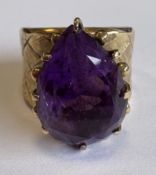 A single-stone amethyst ring of stylised form set in gold.