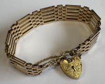 A heavy engine-turned 9 carat bracelet with heart-shaped padlock.