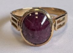 A single-stone cabochon ruby ring in gold setting.