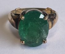 A large single-stone emerald ring in gold setting.
