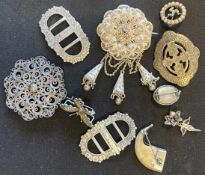 A small collection of filigree silver brooches, buckles etc.