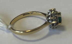 A small gold emerald and diamond ring.
