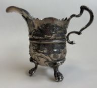 DUBLIN: An Irish silver jug on feet with embossed