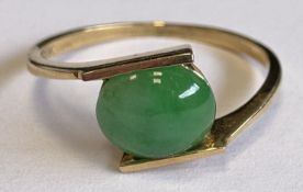 An 18 carat gold jade-set ring.