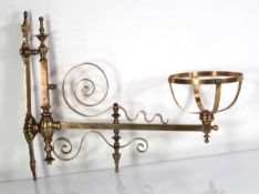 In the manner of W.A.S. Benson, a brass and copper-finished wall-mounted oil lamp holder with a