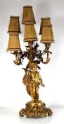 A gilt metal six branch table lamp of figural form modelled as a child holding a basket of