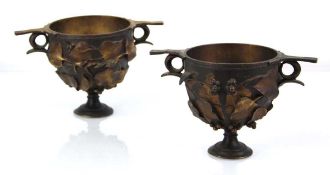 A pair of gilt metal garnitures or open footed bowls, each with a pair of handles and bodies
