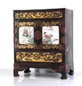A late 19th/early 20th century Japanese Export lacquered table-top cabinet, the two doors set with