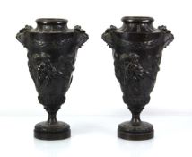 A pair of brown-patinated bronze vases of urn form, each with a metalwares liner, relief decorated