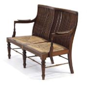 A 20th century mahogany slat back two-seater settee with seagrass woven seats, on turned front