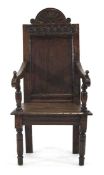 A late 17th century Wainscott chair, the panelled back surmounted by a carved pediment, the arms