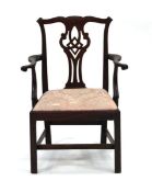 A late Georgian mahogany open armchair with a drop-in seat, on square legs joined by a cross