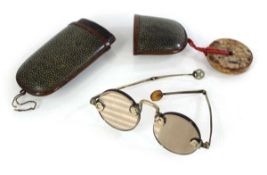 An early 20th century shagreen and copper glasses case with a hardstone pendant attached, containing