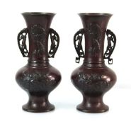A pair of 20th century brown-patinated twin-handled vases relief decorated in the Chinese manner, h.