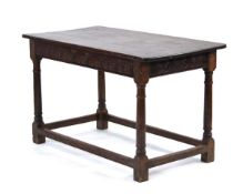 An oak refectory type table, the planked surface over carved a frieze, one end with inverted