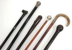 A group of walking sticks and canes including a horn handled silver-mounted example, a swagger