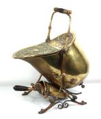 A brass coal scuttle relief decorated with a classical urn, circa 1900, with a matching fitted
