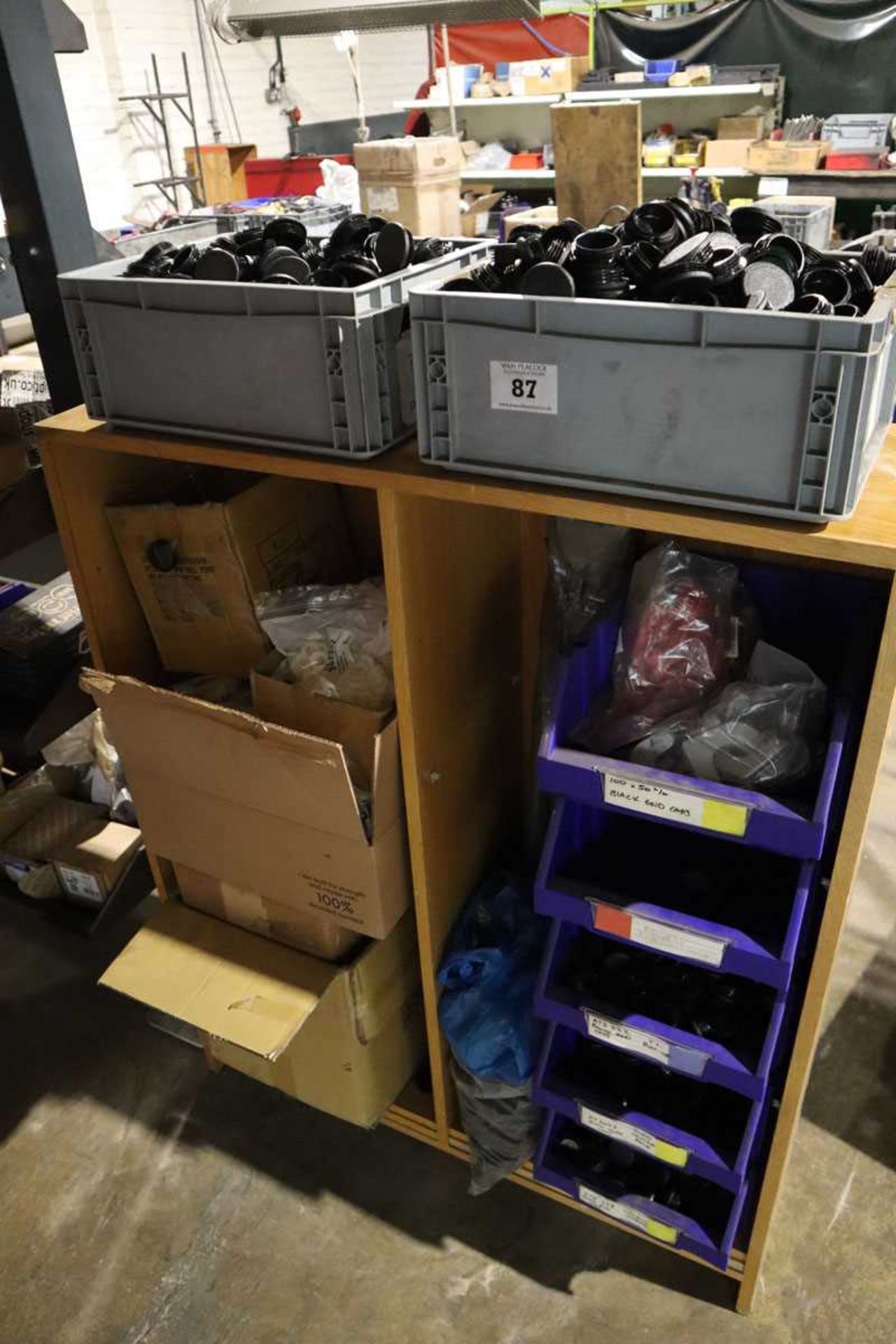 +VAT Open-front wooden shelf unit with contents; plastic threaded caps, plastic washers and similar
