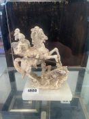 Carved ornament of St George defeating the Dragon, mounted to a white onyx base, the underside