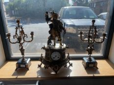 Decorative brass mantel clock with hunter figure, together with a pair of onyx based five branch