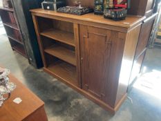 Dark oak open fronted bookcase with single door cupboard section