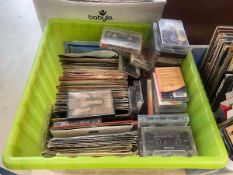 Box containing 7in vinyl records and tape cassettes