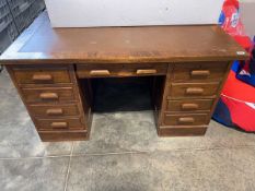 Dark oak finish twin pedestal office desk with an arrangement of 9 drawers and inset brown leather