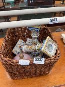 Wicker waste paper basket with a pair of porcelain candlesticks and a lidded glass bowl