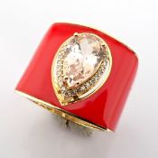 A luxurious gold ring featuring orange laser enamel, elegantly adorned with vibrant morganite and