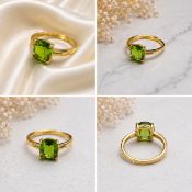 Title: Green Cushion-Cut Stone Gold-Tone Ring Description: Elegant gold-tone ring featuring a