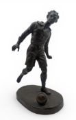 A BRONZED SCULPTURE OF A FOOTBALLER
