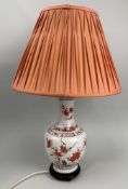 A CHINESE STYLE TABLE LAMP WITH FLORAL DECORATION ON A WOODEN BASE WITH A RIBBED RED SHADE