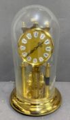 A kern 400 day anniversary torsion clock with a glass dome