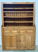 A Victorian pine dresser comprising of two drawers over a two door cupboard with a three shelf plate