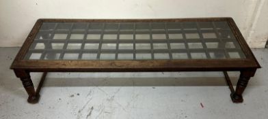 A oak glass topped coffee table on turned supports (H32cm x 130cm x 52cm) Condition Report Some